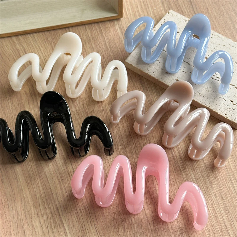 Die Fluid Wave Silhouette-Haarspange in verträumten, durchscheinenden Farbtönen bietet sicheren Halt für unordentliche Duttfrisuren und moderne, minimalistische Hochsteckfrisuren.