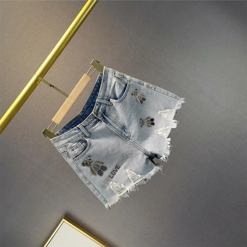 

Новые летние джинсовые шорты с высокой талией и рваным краем для женщин, с эффектом потертости и стразами в виде медведя, европейский тренд 2026 года