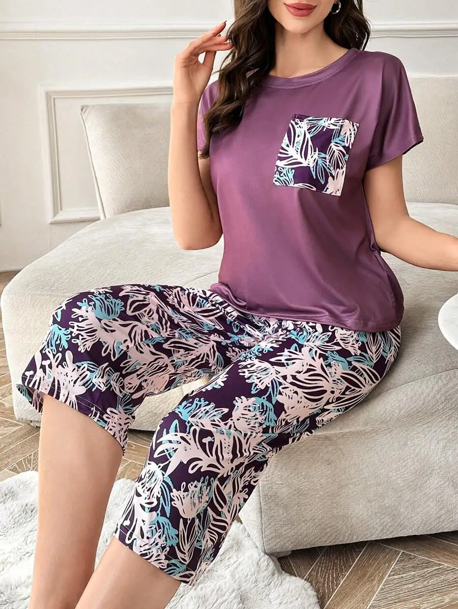 

Фиолетовый топ с короткими рукавами, цветочным принтом на кармане и комплектом брюк-капри в тон.