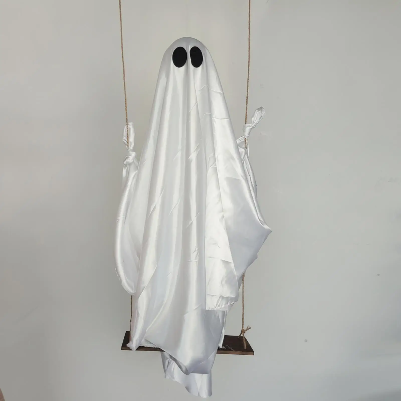 木製の板で吊るしたお化け。ハロウィーンの装飾に最適。屋外で使用可能。玄関や入り口に飾るのに。