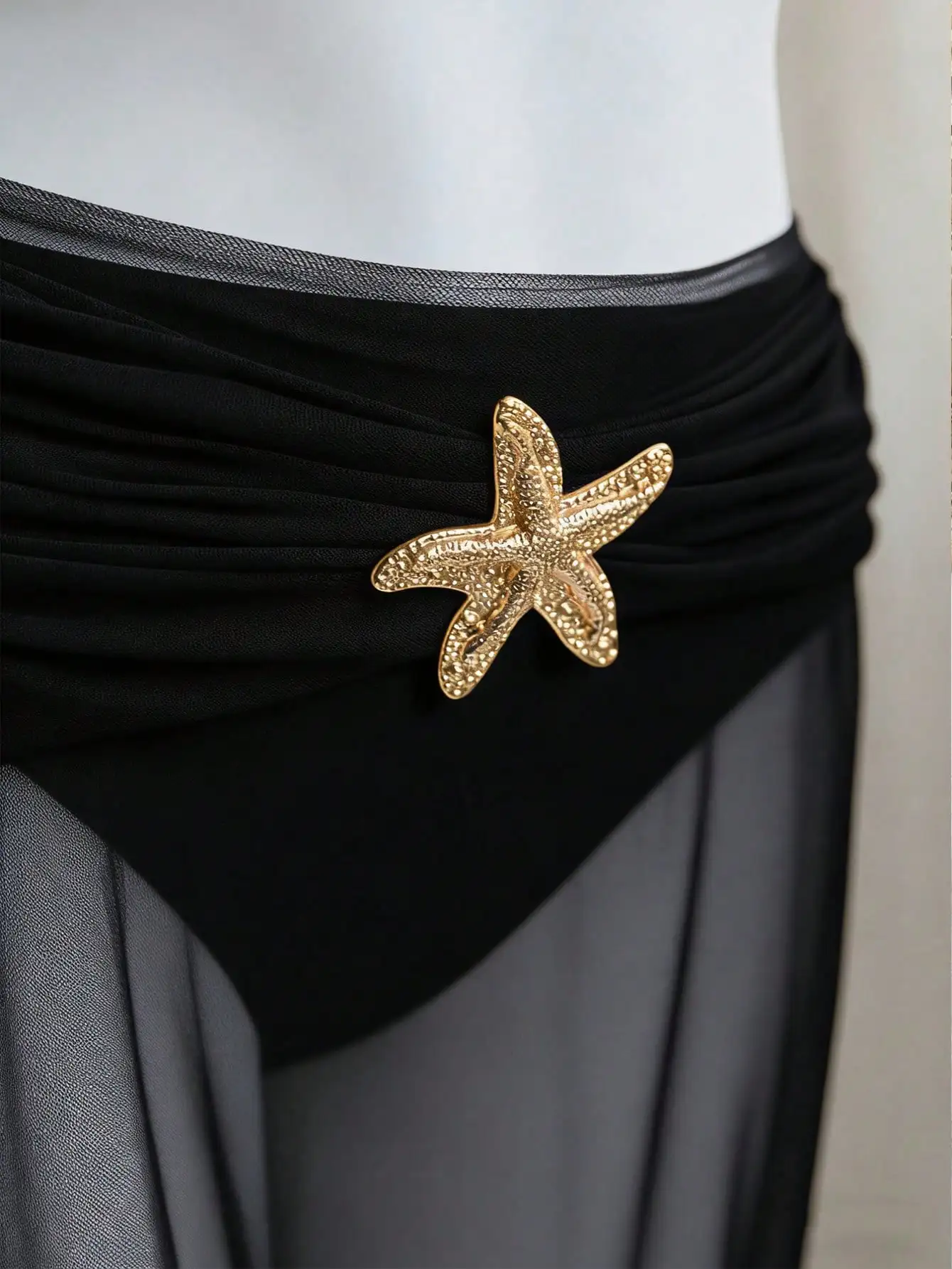 

Черный комплект бикини с завязками на шее, золотой застежкой в виде морской звезды, трикотажными трусиками-треугольниками и прозрачной юбкой-накидкой для пляжа и бассейна