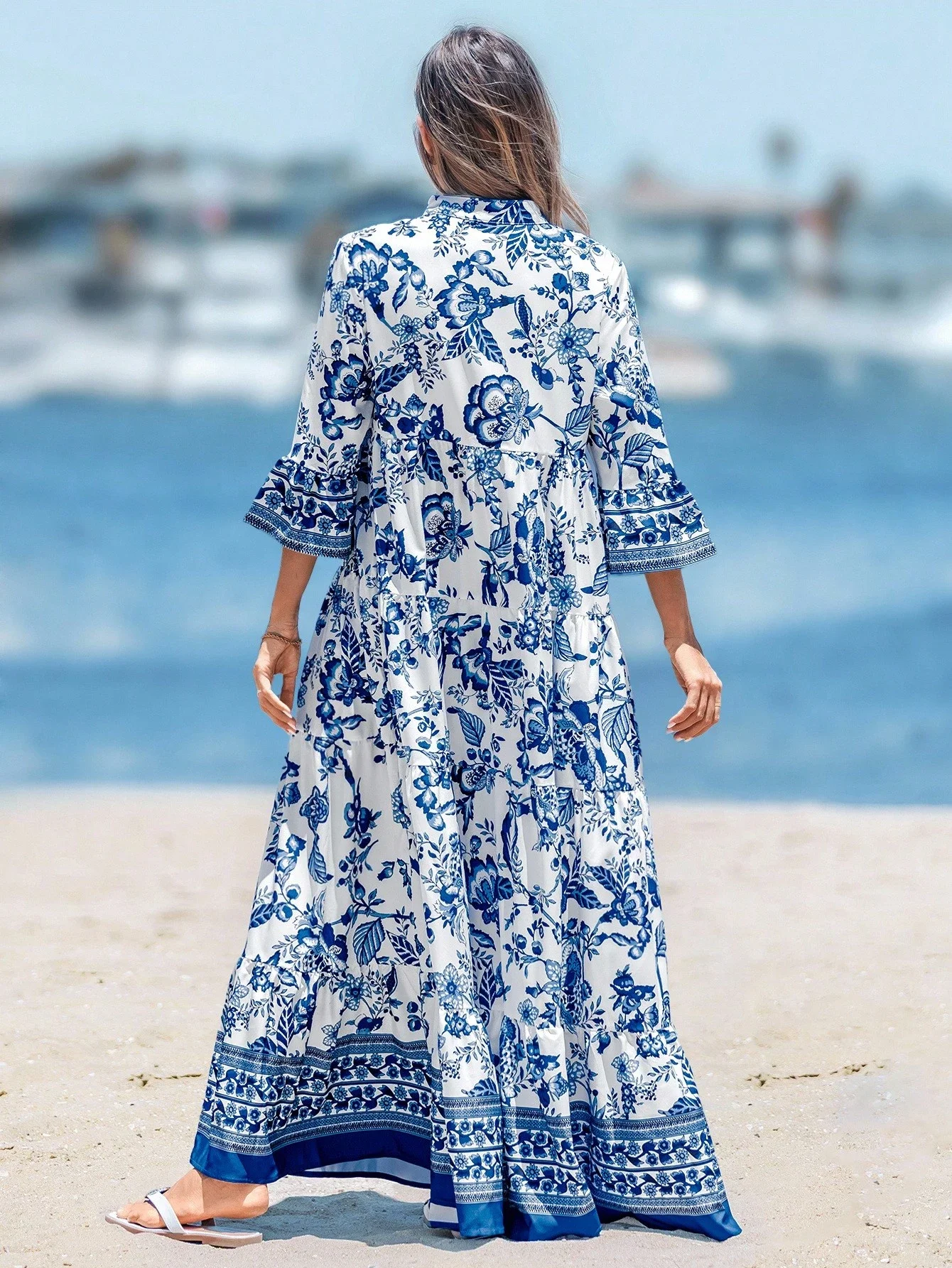 

Женское длинное платье сине-белого цвета с цветочным принтом и расклешенными рукавами для пляжного отдыха