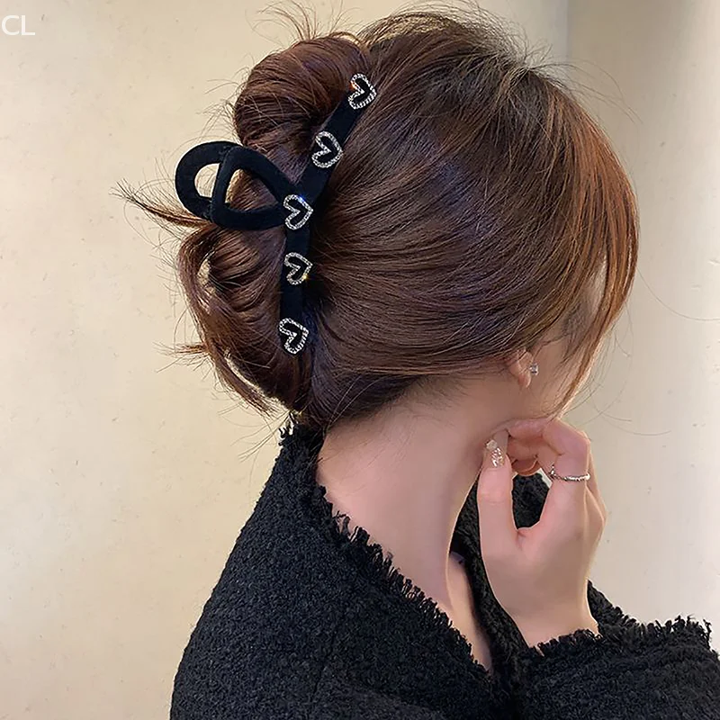 말꼬리 팬 스타일을 위한 라인스톤 디테일이 있는 절묘한 블랙 플로킹 헤어 클립.