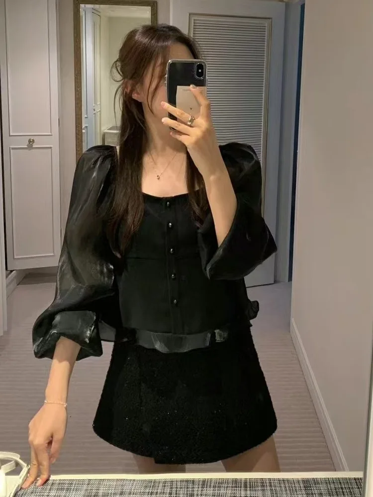 قميص أنيق بياقة مربعة وأكمام منتفخة مع أزرار دقيقة وحواف دانتيل، يضفي أجواء نهاية العام، مزين باللؤلؤ واللمعان وأكمام طويلة