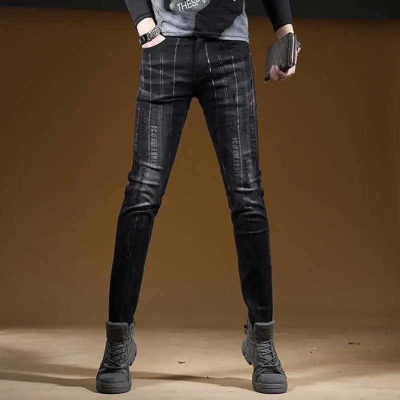 Vaqueros de vaquero con letras negras bordadas para hombre, pies pequeños, tendencia coreana, pantalones elásticos versátiles rasgados, pantalones vaqueros ajustados