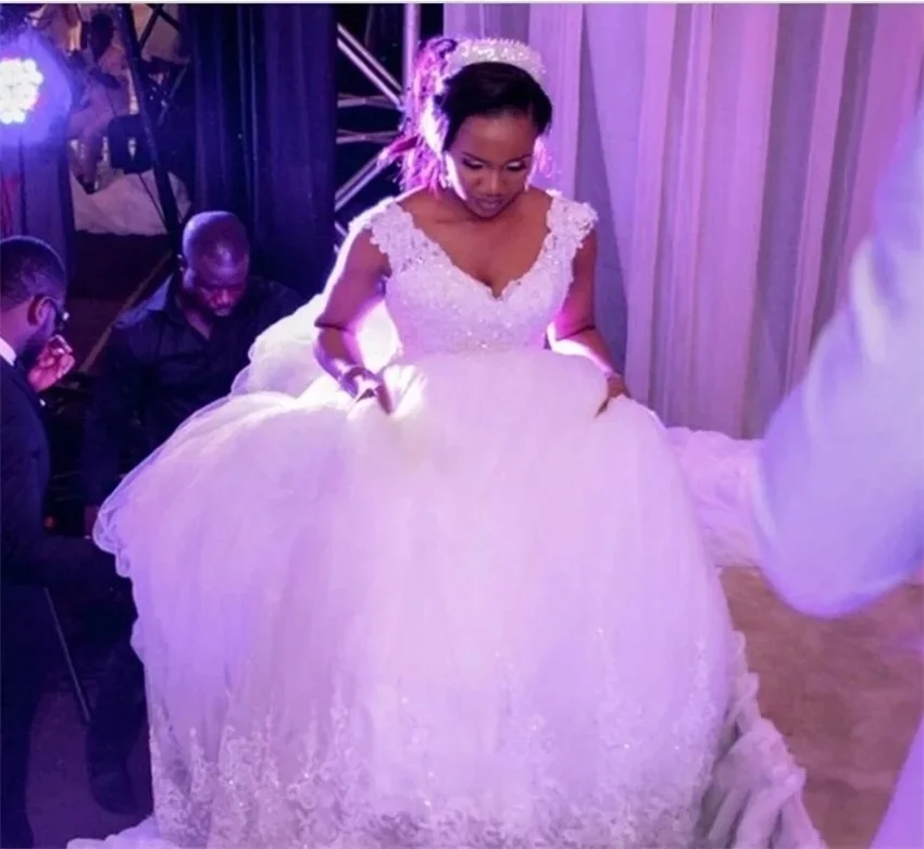 

Свадебные платья Flavinke на заказ: белое бальное платье без рукавов с бисером, кружевными аппликациями, V-образным вырезом и шлейфом, большие размеры