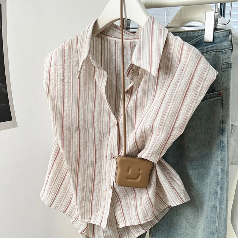 Camicia a righe asimmetrica allentata con bottoni alla moda Abbigliamento femminile 2025 Estate Nuove magliette casual Camicetta da donna senza maniche da ufficio
