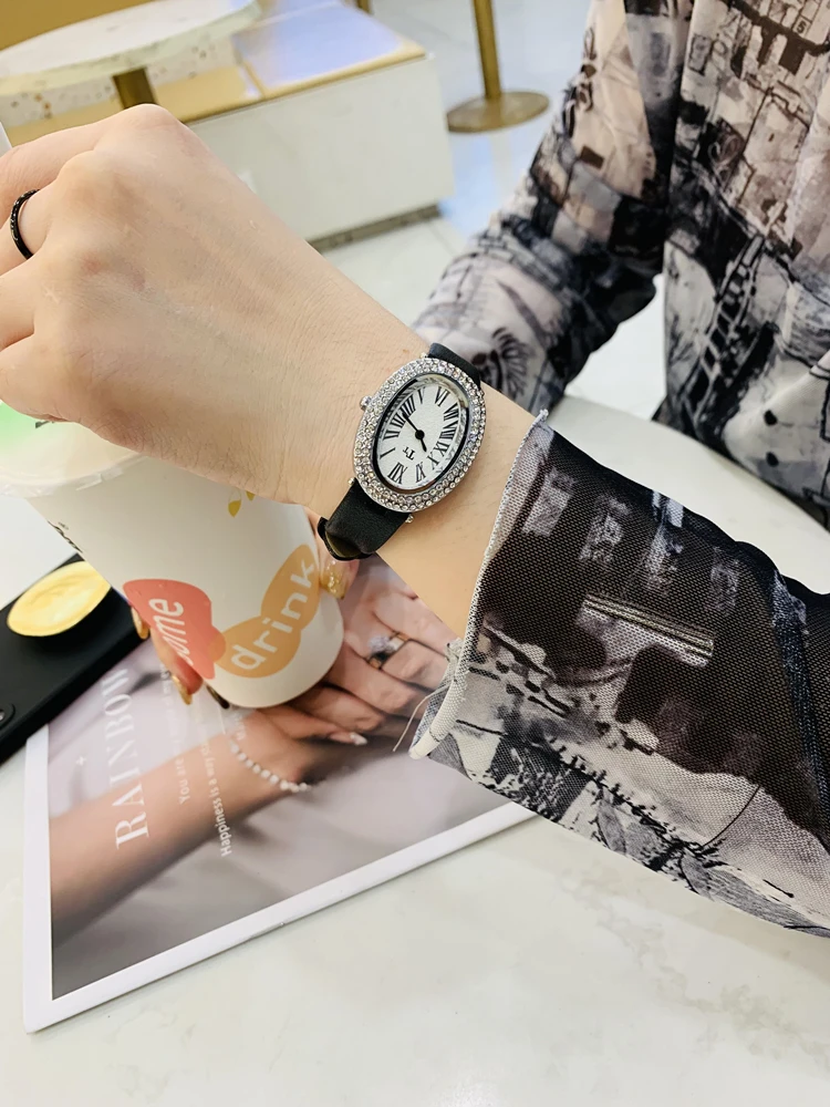 

Oval-shaped women's watch with a vintage, luxurious feel and a high-end leather strap; fashionable quartz wristwatch.