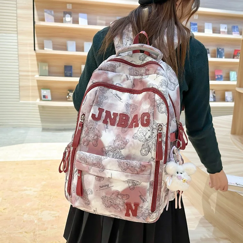 sac-a-dos-traveasy-2026-nouveau-style-tie-dye-a-imprime-floral-pour-filles-en-nylon-avec-pendentif-en-peluche-style-preppy-cartable-d'ecoliere