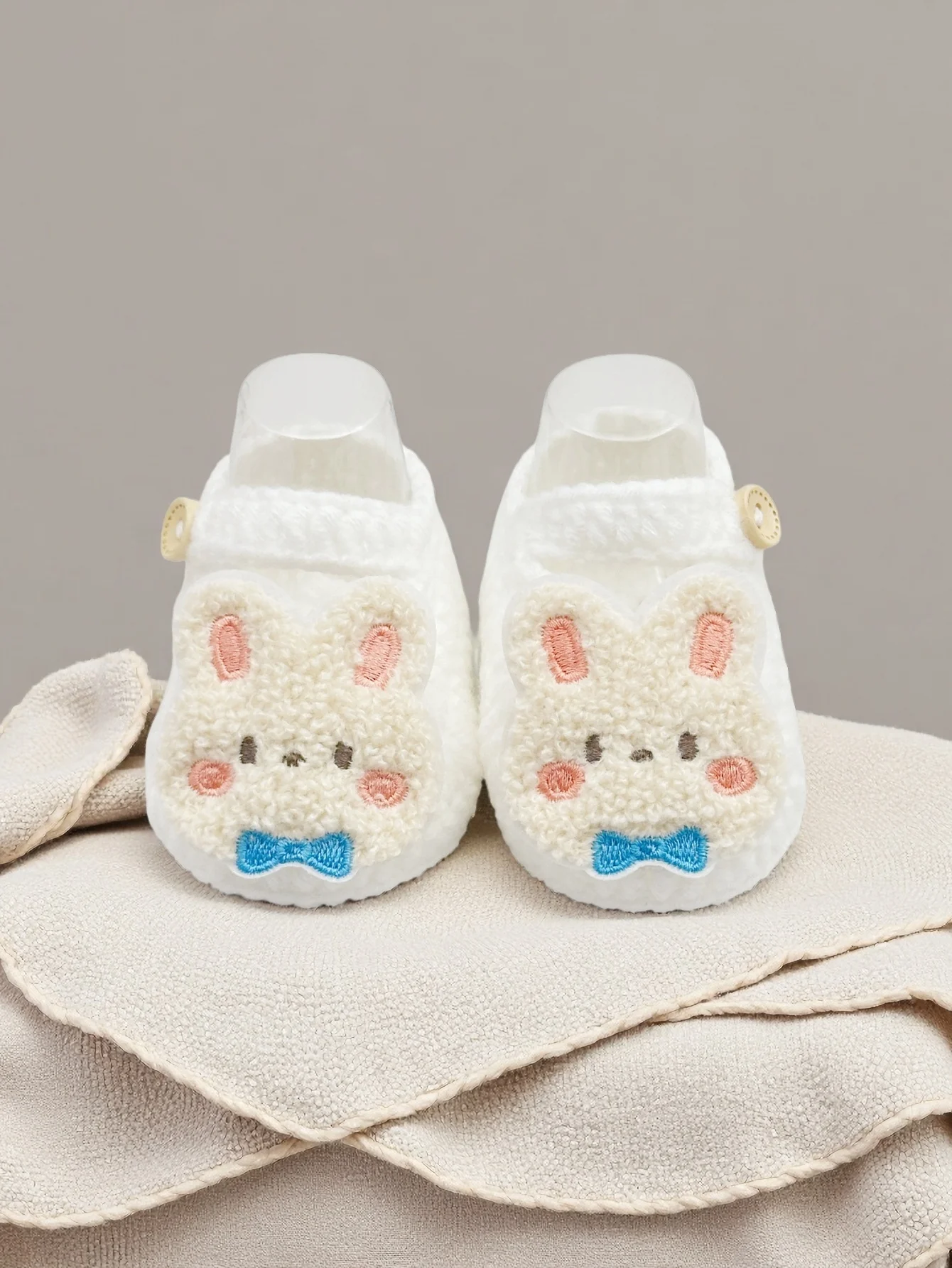زوج واحد من أحذية الأطفال اللطيفة على شكل أرنب، أحذية شبشب محبوكة بيضاء مع فيونكة زرقاء، أحذية ناعمة للرضع مع زر إغلاق، 0-12 شهرًا