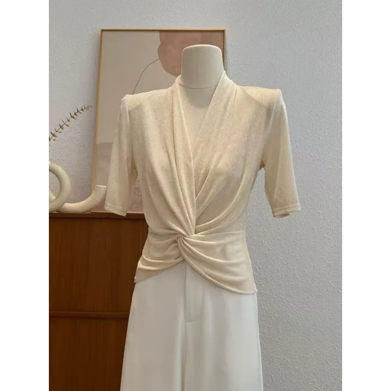 เสื้อยืดแขนสั้นดีไซน์หรูหราทันสมัยสำหรับผู้หญิง ปี 2025 คอวี ดีไซน์เกลียว โดดเด่น สง่างาม สีขาว