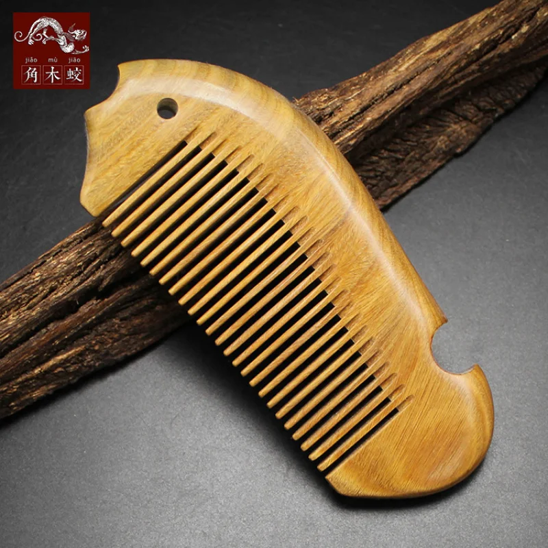 

Маленькая расческа из зеленого сандалового дерева с мелкими зубцами в форме рыбы, изготовленная из цельного дерева.