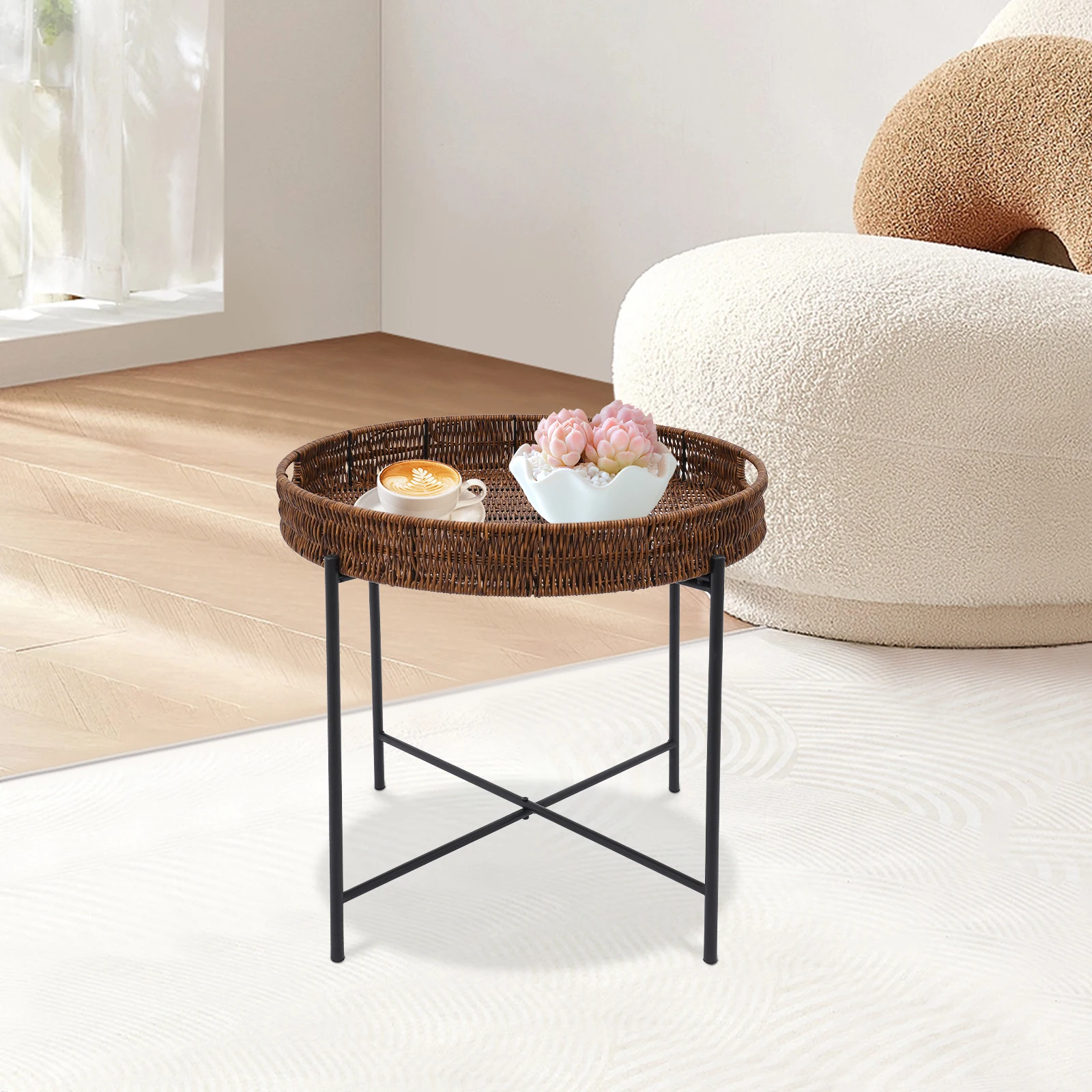 Rotan bijzettafel met cappuccino en roze pioenrozen naast een bouclé poef