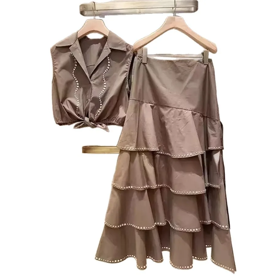 

Женский модный комплект: топ без рукавов с воротником-стойкой, украшенный стразами, с завязками на талии и юбка-кейк. Элегантный комплект.