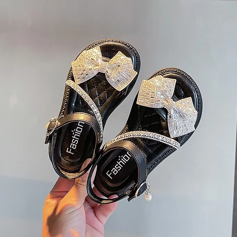 

2025 детские сандалии на плоской подошве со стразами, детские летние милые сандалии с бантом для девочек, пляжные сандалии, модная римская школьная обувь принцессы