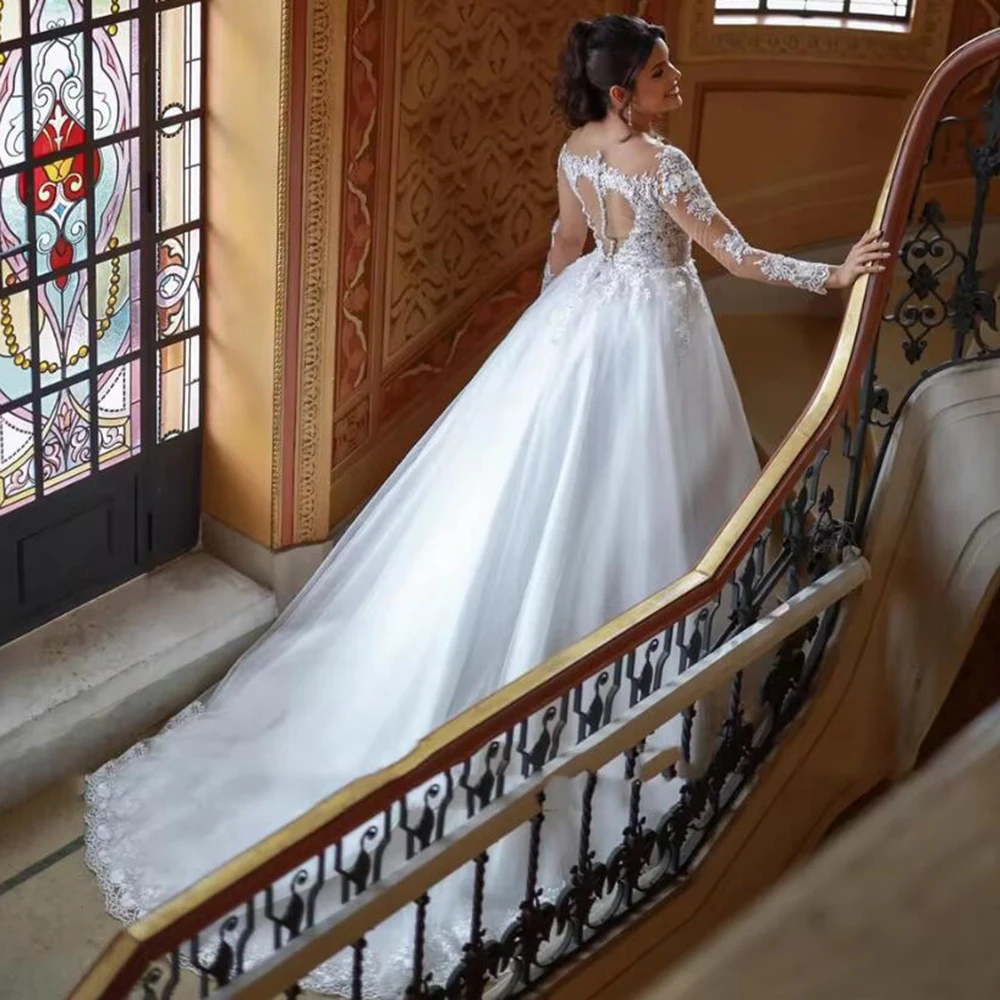 Eleganckie suknie ślubne w kształcie litery A z koronkowymi aplikacjami i koralikami, z iluzorycznymi długimi rękawami i dekoltem typu iluzja, szyte na miarę.