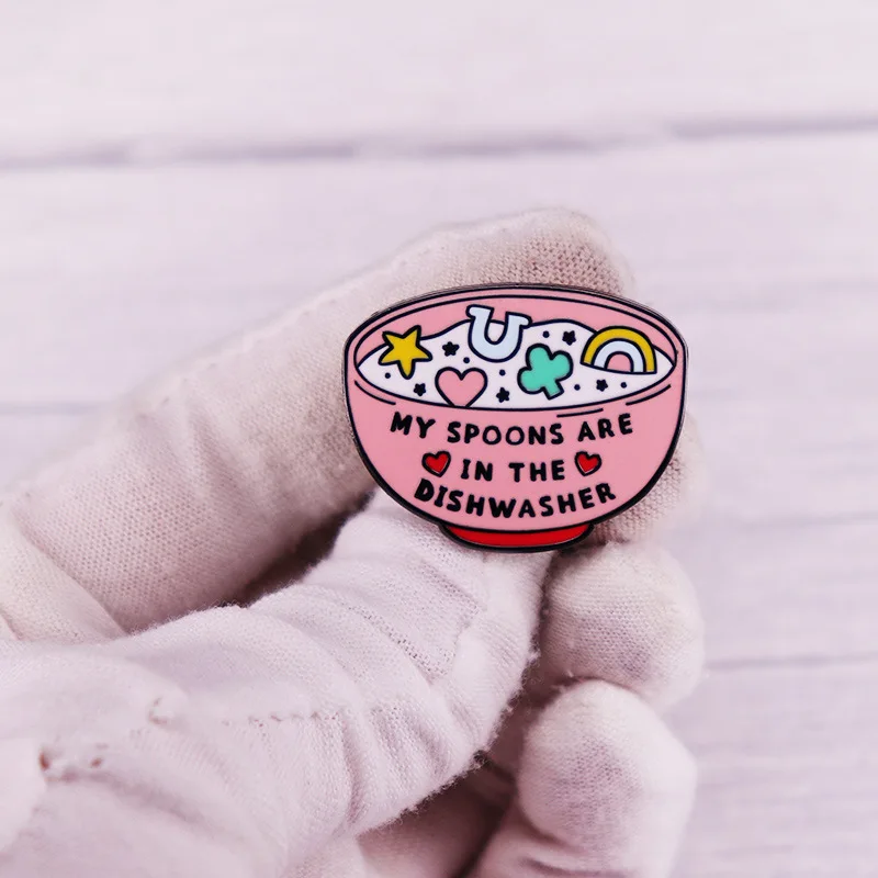 My spoon is in the dishwasher with enamel pins, interesting hat and backpack decorations