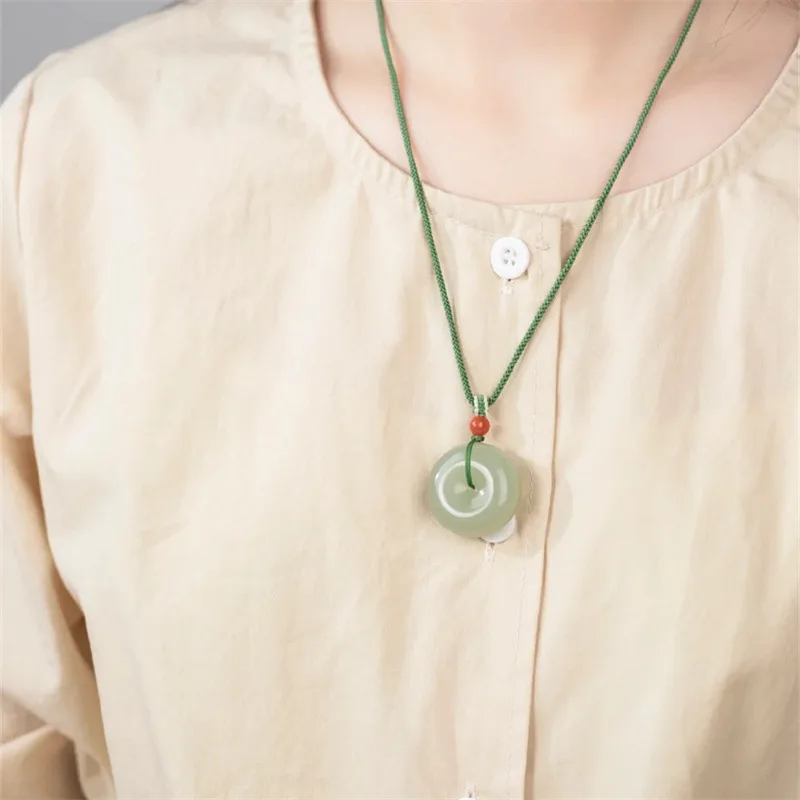 A simple, light green pendant featuring a Qing water design, with a blue-white jade safety clasp