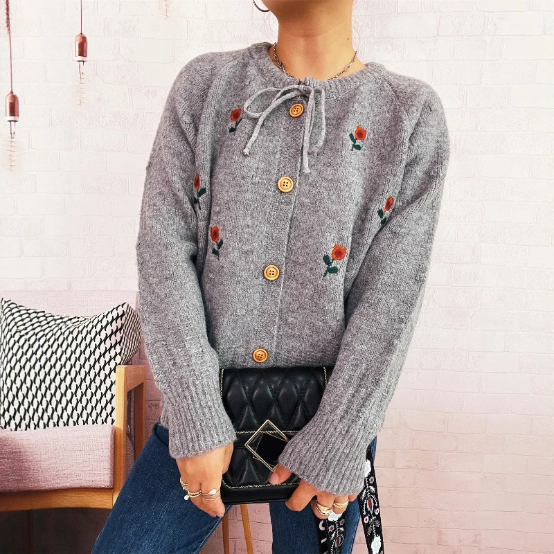 Nowy sweter-płaszcz damski na jesień/zimę 2025, z haftowanymi kwiatami, kokardą i zapinany na jeden guzik.