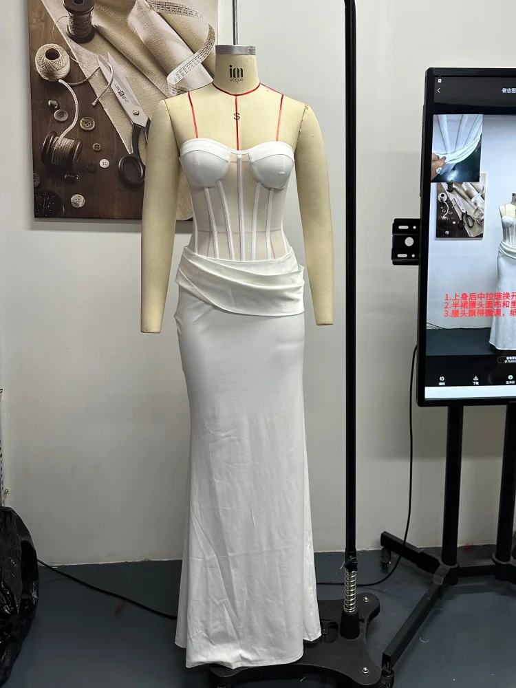 

Элегантный белый комплект из двух предметов: корсет без бретелек и прозрачное макси-платье для женщин. Современный минималистичный наряд для помолвки или выпускного вечера.