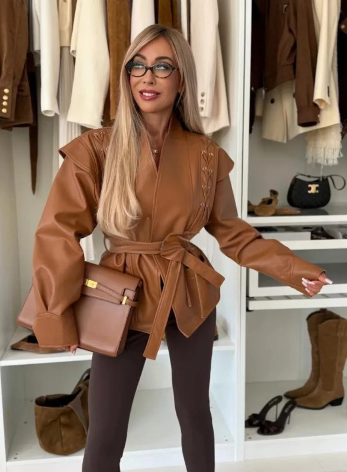 Krótka skórzana kurtka damska sznurowana, dopasowany krój, dekolt w serek, podkreślająca talię, jesienna moda damska, casualowa odzież wierzchnia w stylu streetwear.