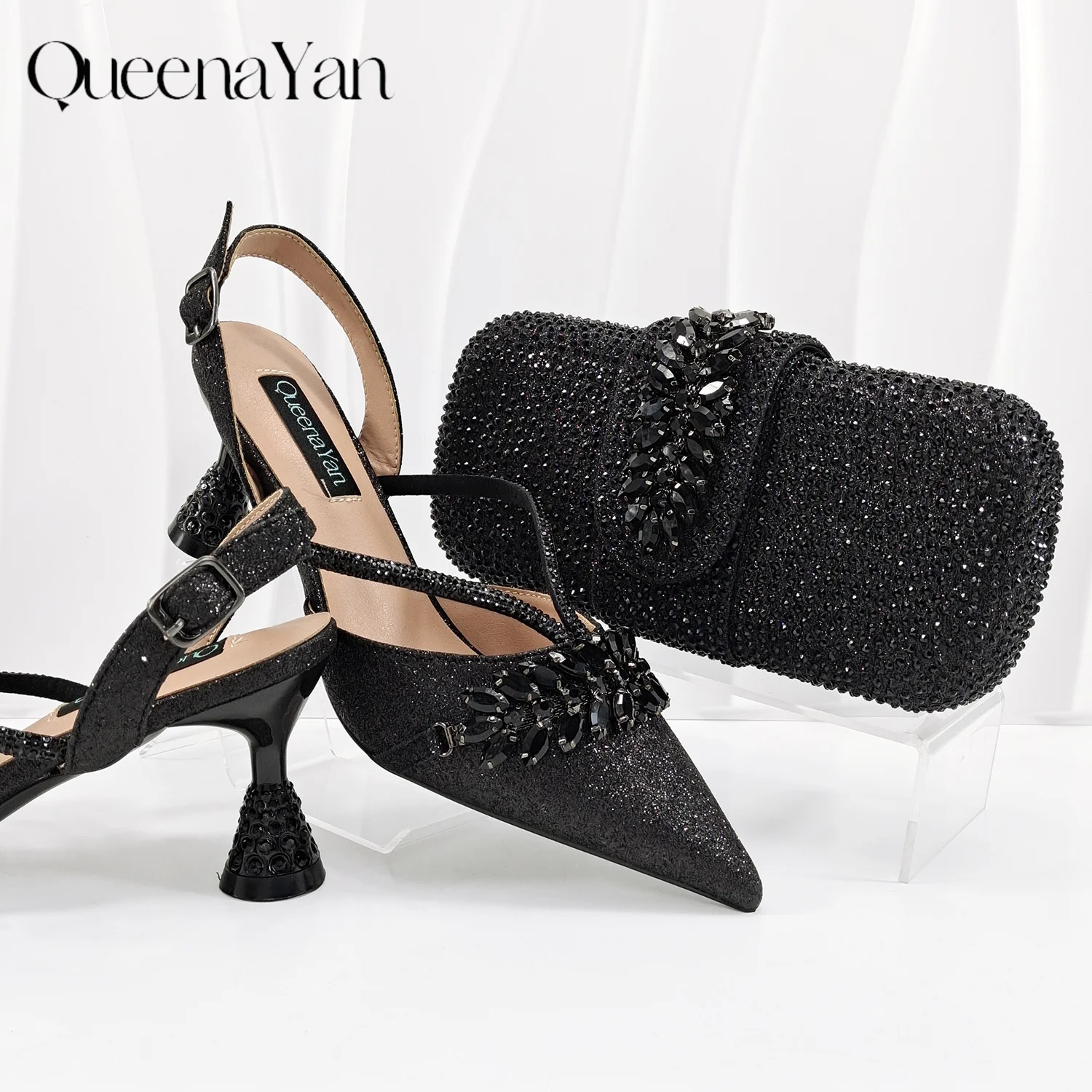 

Новинка от Queena Yan: комплект из туфель на высоком каблуке с острым носком и сумки, украшенных черными стразами, для вечеринок и свадеб.
