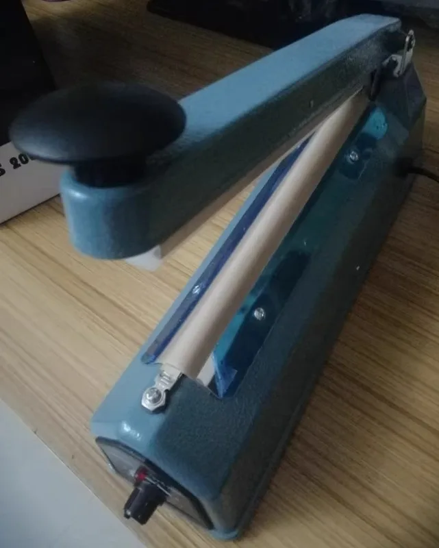 

8-скоростная регулируемая машина для запайки пакетов под давлением - модель 400. Корпус железного цвета. Машина для запайки пленки 5/8 мм.