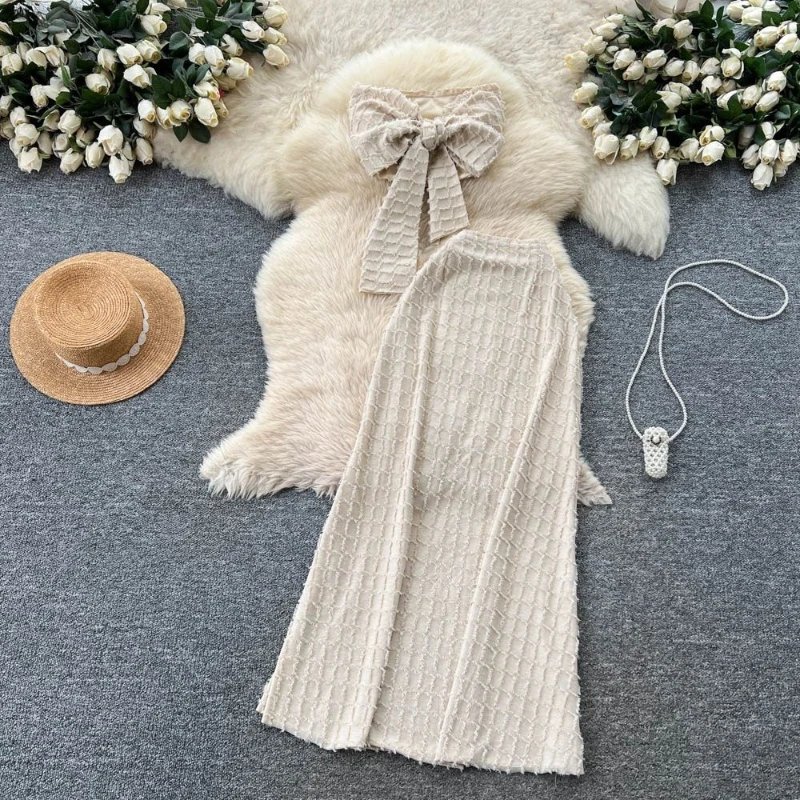 

Элегантный вязаный комплект из двух предметов: женский летний топ без бретелек с бантом и длинная юбка А-силуэта с высокой талией.