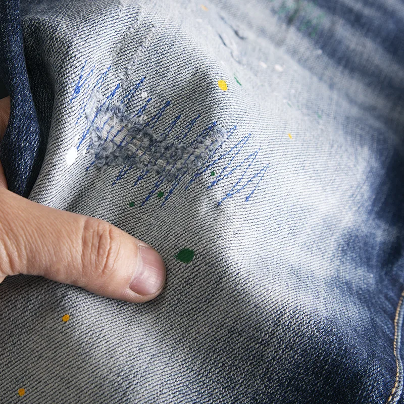 Jeans stampati con lettere di vernice splashate con foro rotto per pantaloni elastici a gamba dritta piccoli slim fit di marca di moda da strada da uomo