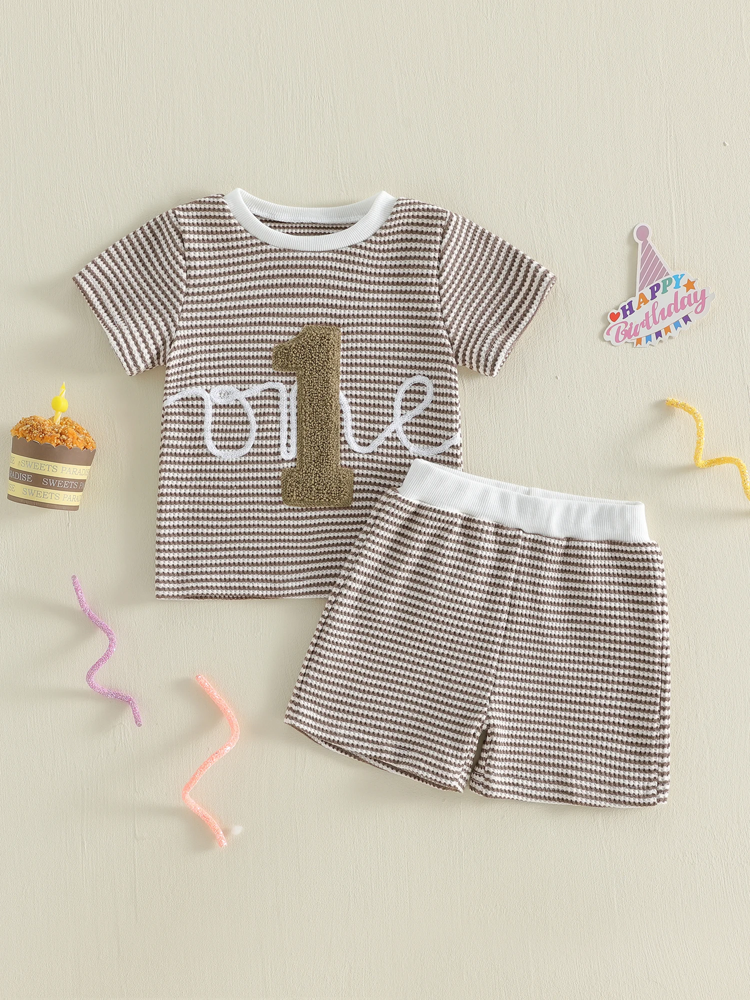 

Милые наряды для девочек на первый день рождения: очаровательный комплект из топа с цветочным принтом, рукавами с рюшами, круглым вырезом и шорт с бантом.