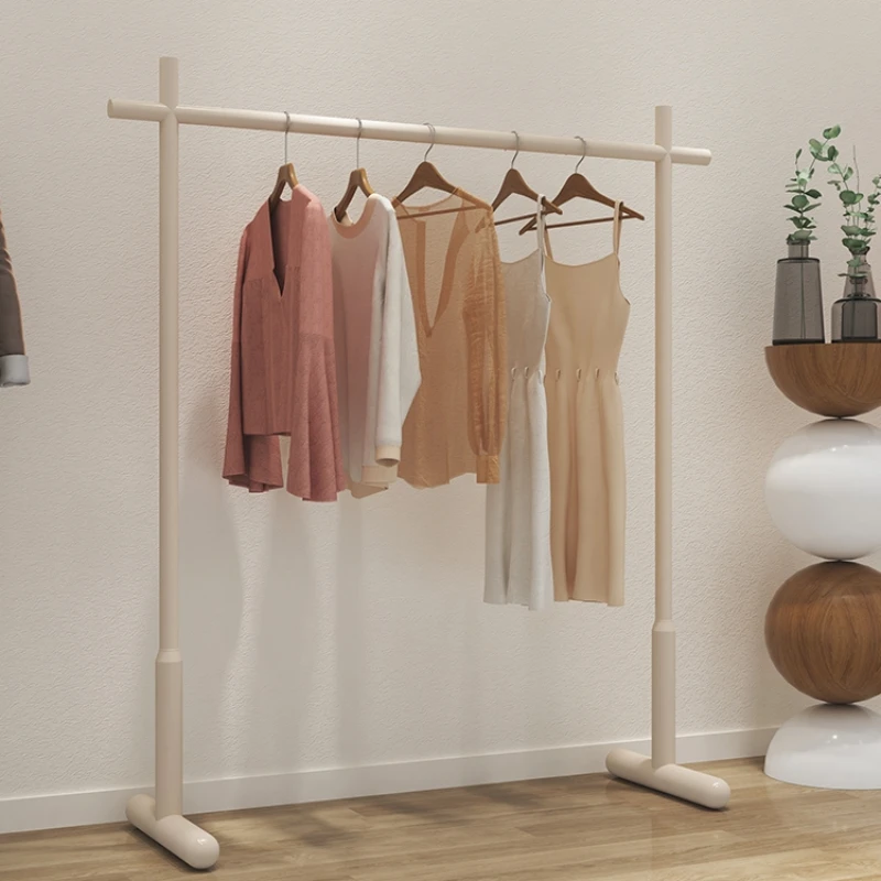 The clothes hanger is foldable on the ground, and there is a small space with cream air in the bedroom for cool drying