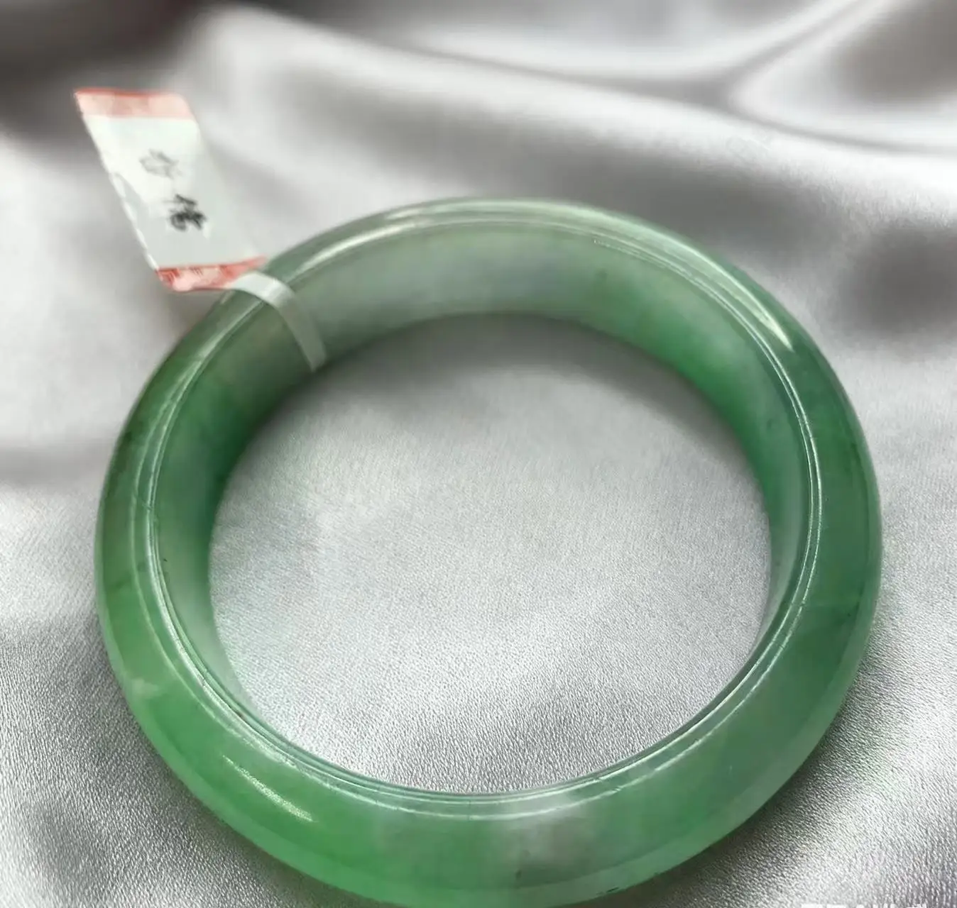 

Один на одной настоящей стрельбе браслета из светло-зеленого нефрита большого размера 58,4 мм.