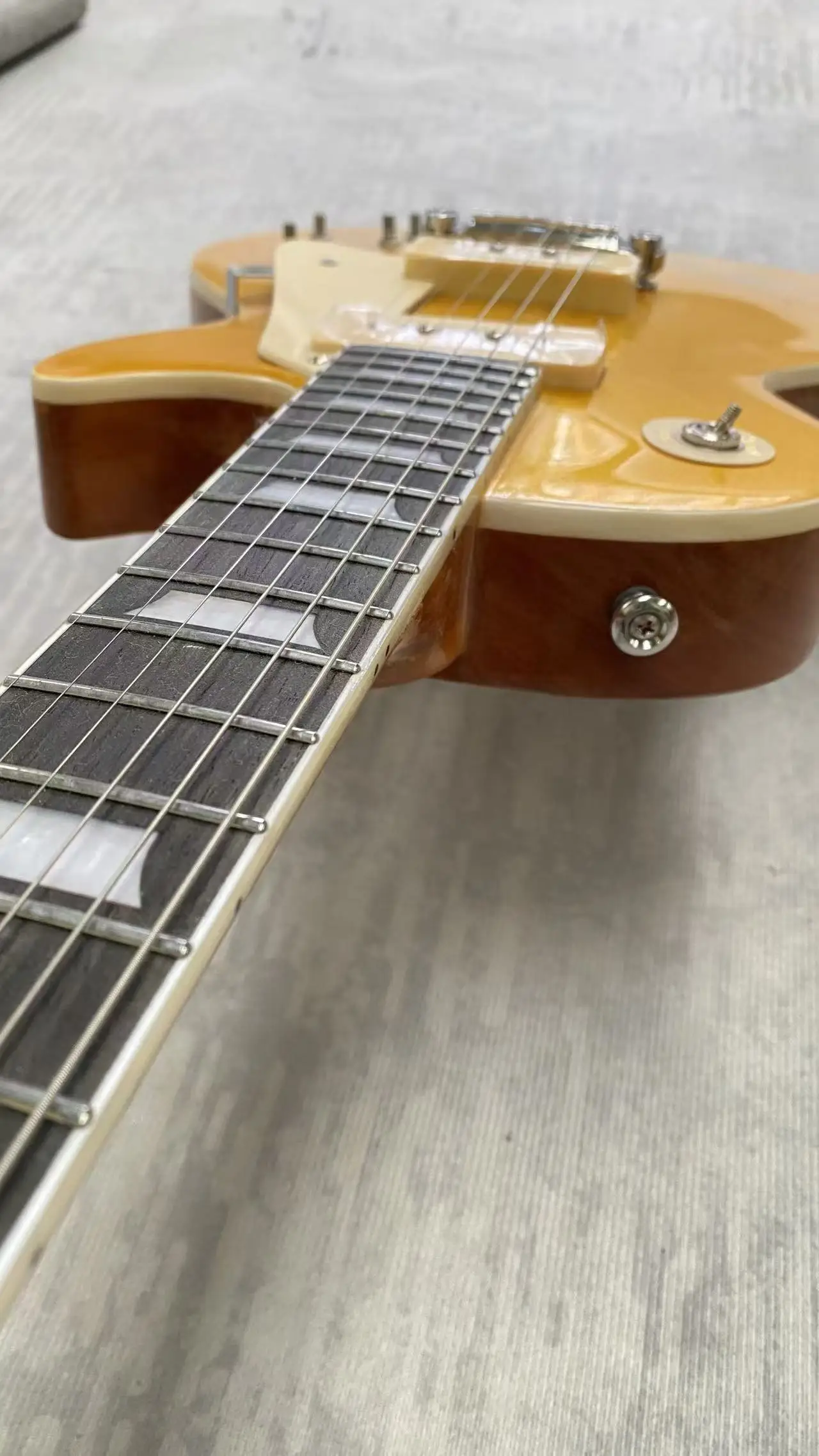 

Electric guitar made in China, with silver metallic finish and yellow color.