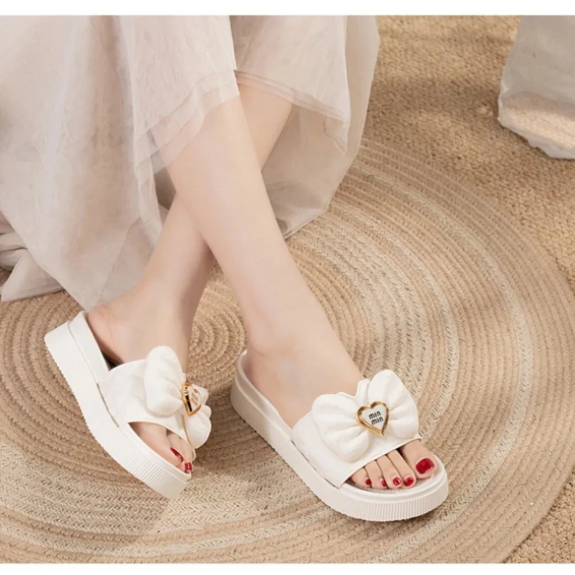 

Женские тапочки, летние шлепанцы с бантом и сердечком, мягкие сандалии, уличные пляжные домашние сандалии на толстой подошве, нескользящие сандалии на платформе, 2025 г.