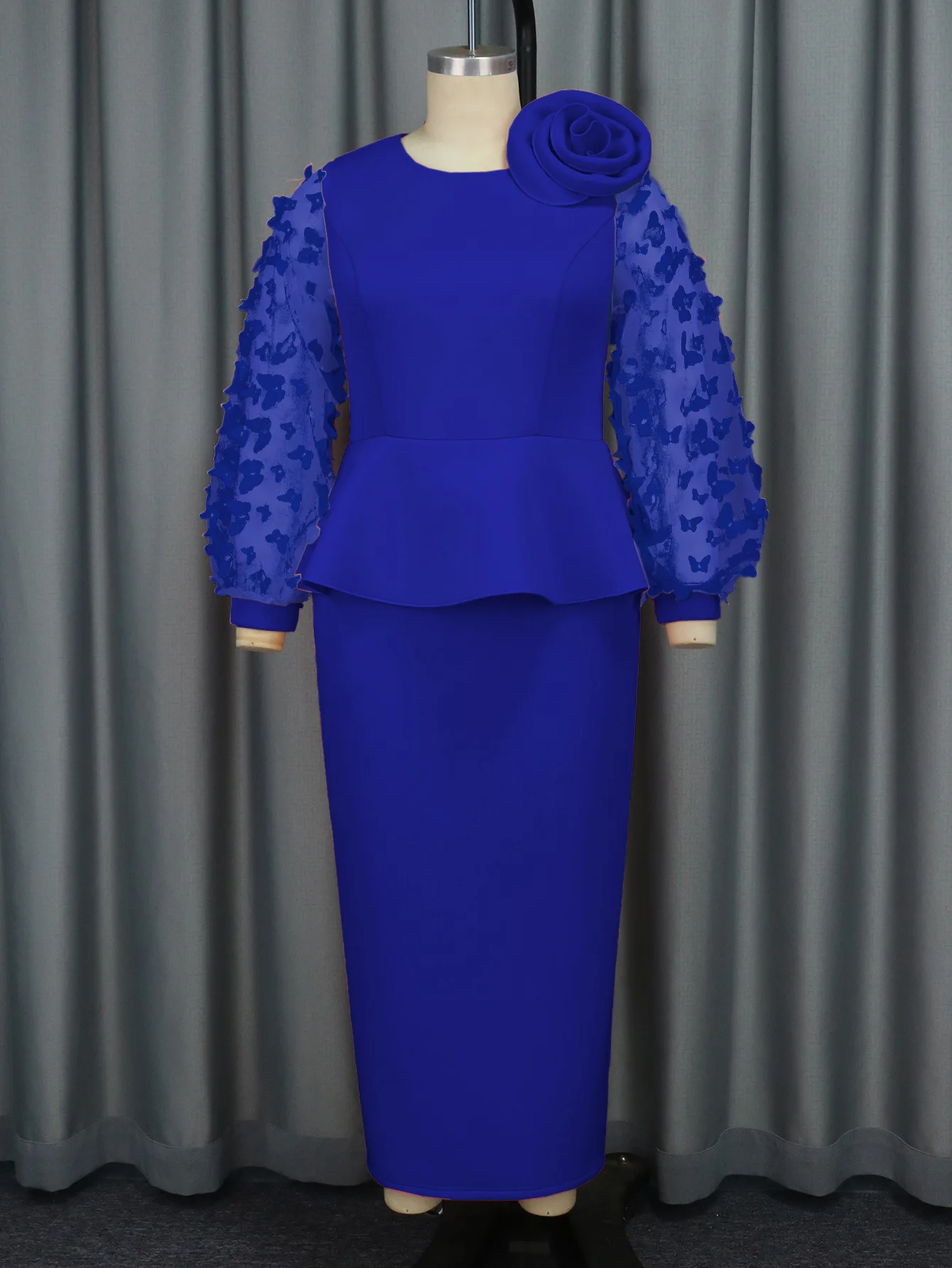 Elegancka sukienka wieczorowa plus size z falbanami w talii, kwiatami na ramionach i długimi, zwiewnymi rękawami z motywem motyla.