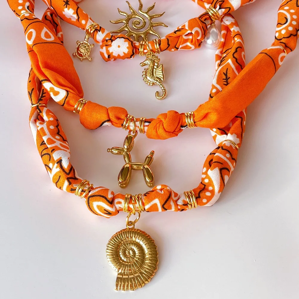 

Orange Bandana Necklace with Gold Plated Charms – Sun, Balloon Dog, Star, Heart, Conch, Fruit, Flower, Perfume