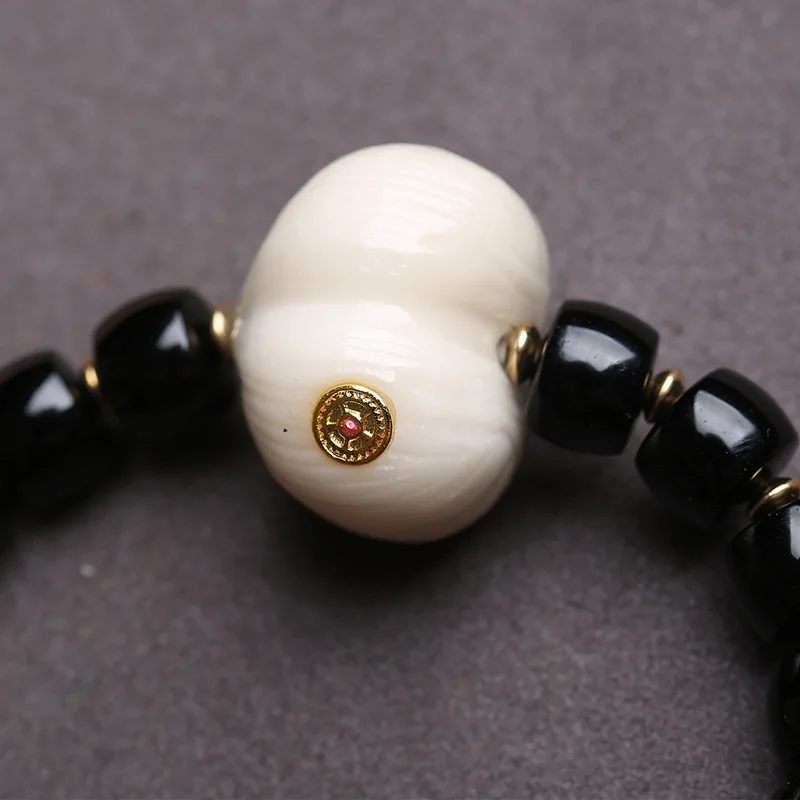 Natural black agate bracelet with barrel beads, reverse-flow bone, peace knot, ivory fruit, peach, monkey head and bodhi seeds - view 2