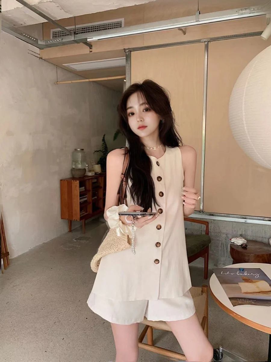 

Летний комплект 2024: модный женский ансамбль из свободного безрукавного топа и шорт с высокой талией, создающих стройнящий эффект, с застежкой на пуговицы.