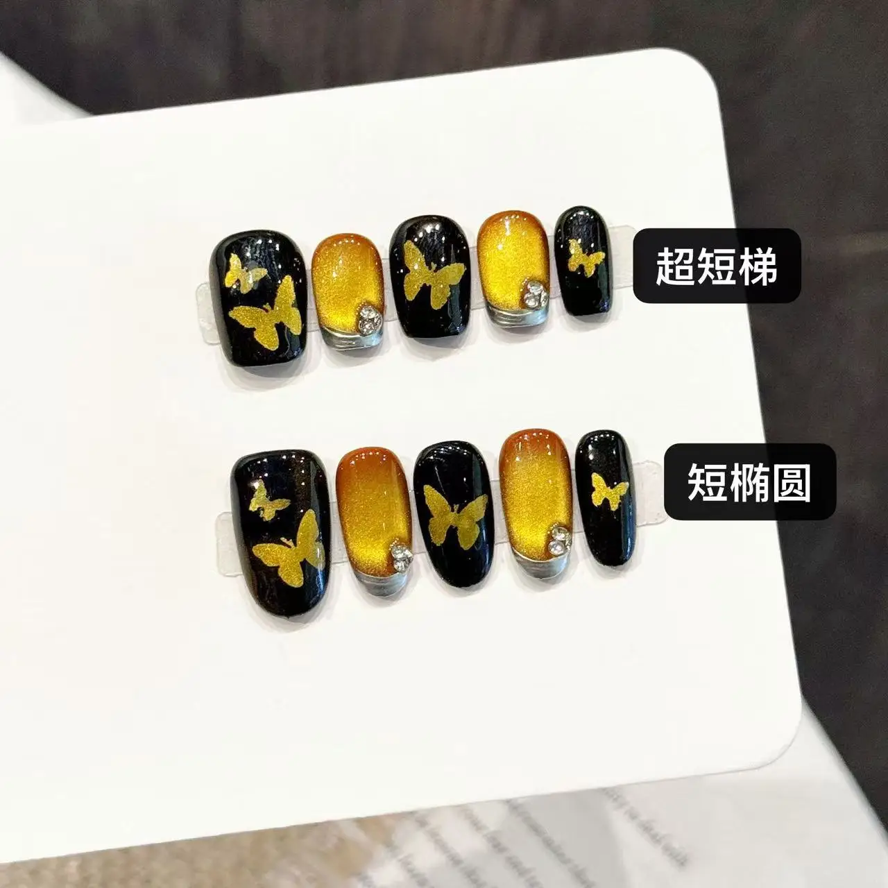 10 個の光沢のあるゴールドの蝶のプレスオンネイル、スイートクールシルバーエッジフレンチスタイルの手作り付け爪、ブラックスクエア/アーモンドフェイクネイル