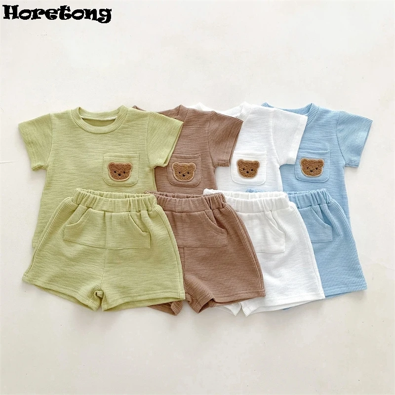 Корейские повседневные детские комплекты, лето 2025 года, с короткими рукавами и шортами, тонкий комплект из двух предметов с вафельным медведем для мальчиков и девочек, модный комфорт Корейские повседневные детские комплекты, лето 2025 года, с короткими рукавами и шортами, тонкий комплект из двух предметов с вафельным медведем для мальчиков и девочек, модный комфорт