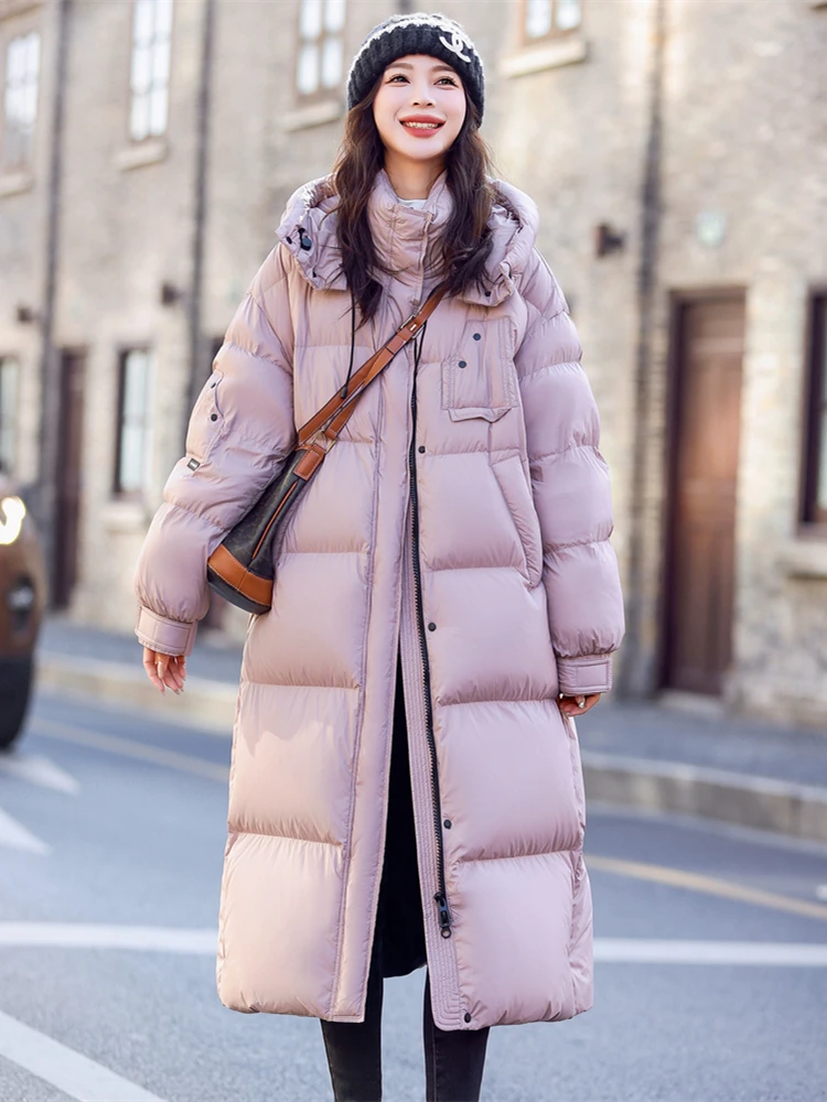 女性のミドル丈の白いダックダウンジャケット、ゆったりとした厚い暖かいジャケット、冬