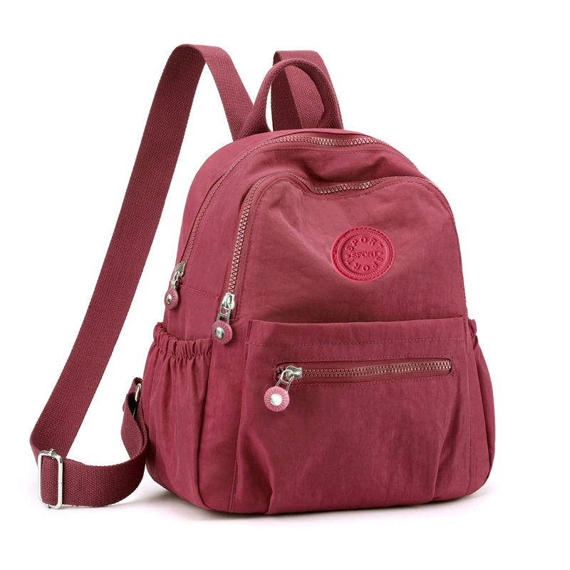 حقيبة ظهر بتصميم محايد للرجال والنساء، مناسبة للسفر والتصوير الفوتوغرافي مصنوعة من مادة النايلون، مع تصميم شعار دائري.