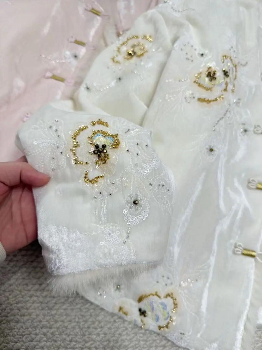 ملابس نسائية جديدة على الطراز الصيني لشتاء 2025 سترة عصرية ودافئة مع تطريز مطرز بالخرز الوردي والأبيض