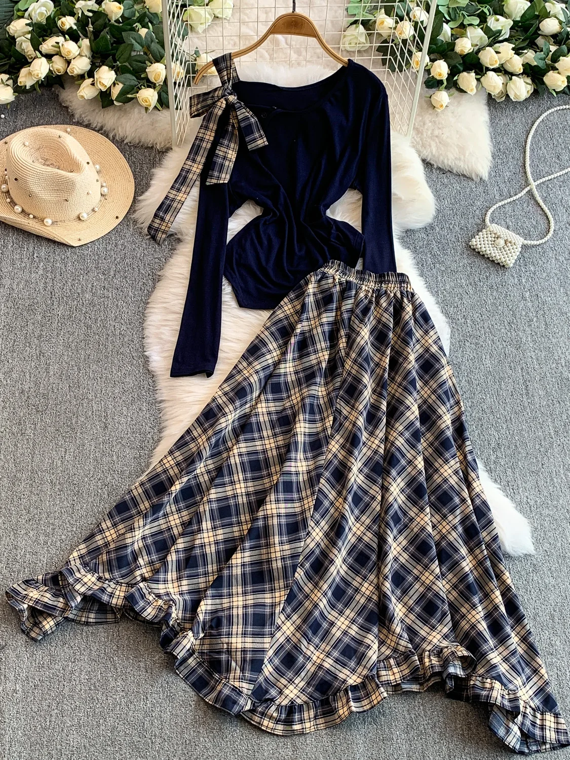 Conjunto de duas peças: Blusa e estilo irmã com babados e alça assimétrica e saia longa com estampa xadrez.