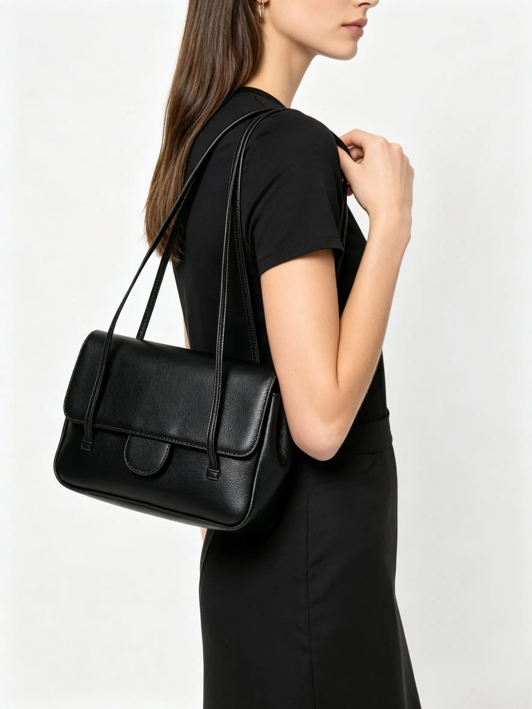 

Black grained leather shoulder bag with minimalist flap closure, long thin straps, and structured rectangular silhouette.