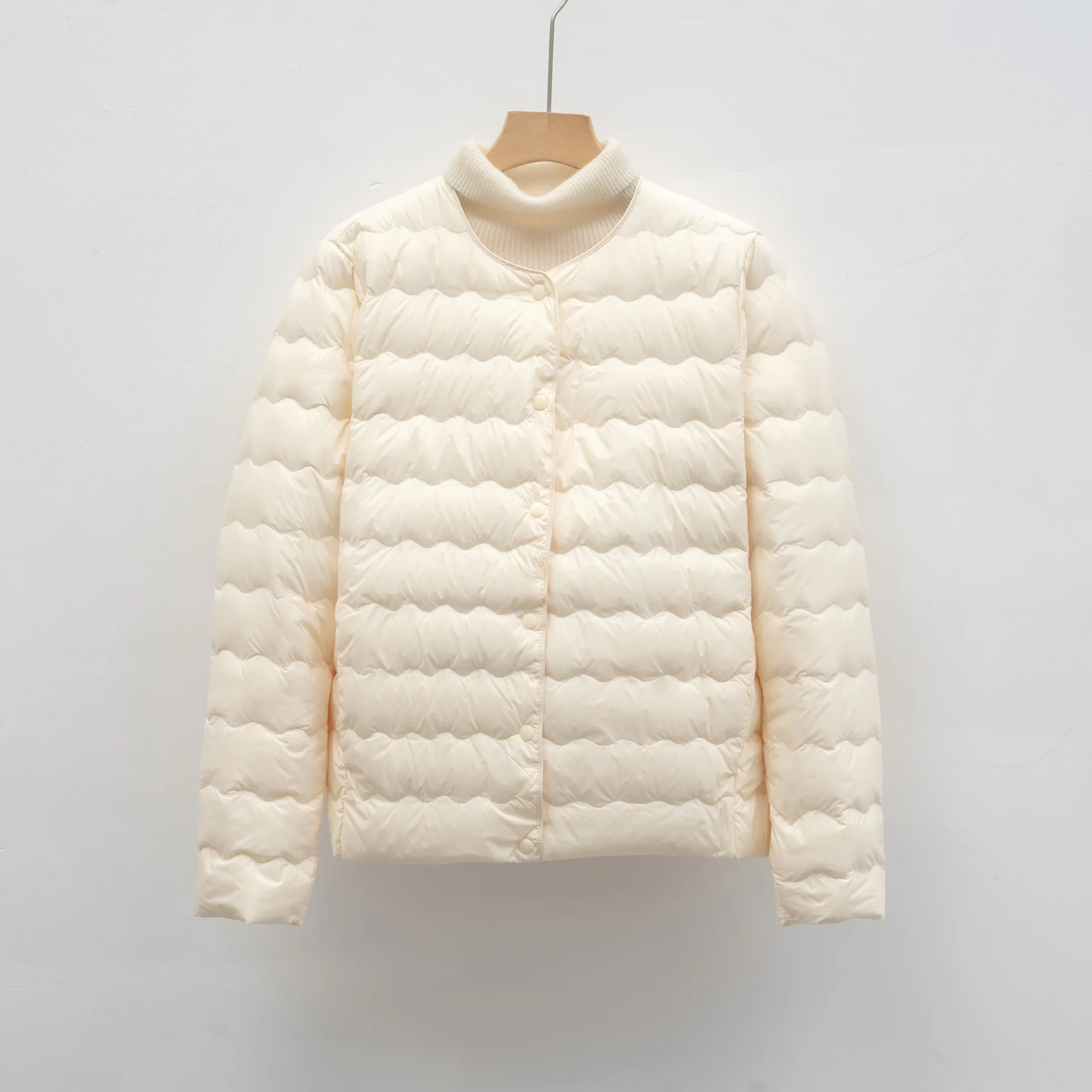 طبقة سفلية مموجة مخيطة مع حشوة 90% سفلية. سترة أنيقة ورقبة دائرية لدفء أنيق وخفيف الوزن تحت أي ملابس.