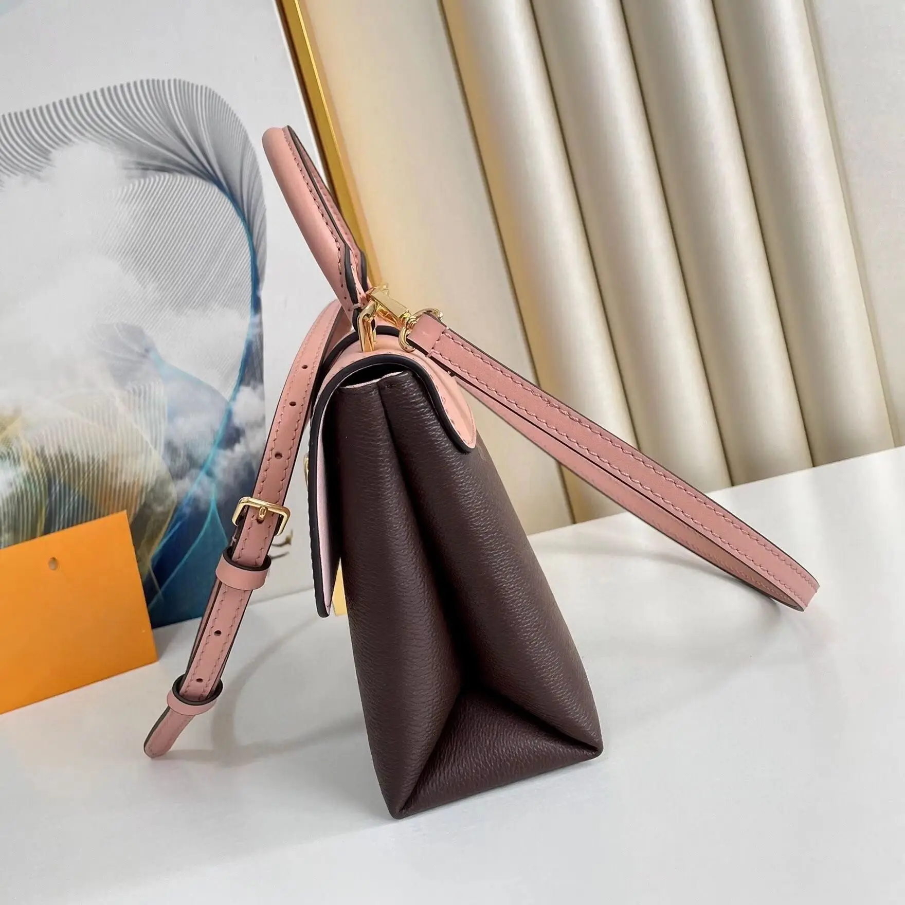 

Mini handbag in pink and taupe leather color-blocking, structured flap design, featuring an oversized gold padlock closure, with matching handle and adjustable crossbody strap.