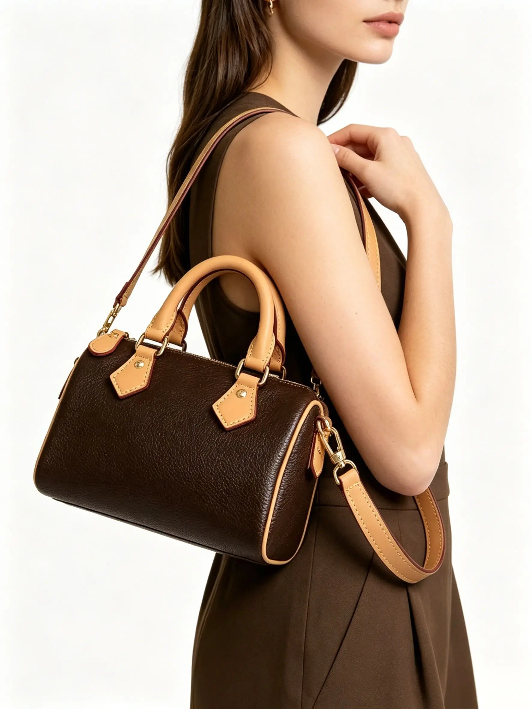 

Mini brown pebbled leather barrel bag with tan leather trim, dual top handles, and a detachable crossbody strap.
