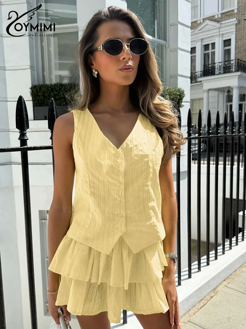 

Женский легкий желтый комплект Oymimi из двух предметов: топ на пуговицах с V-образным вырезом и многоярусная мини-юбка с оборками. Шикарный повседневный образ. Весна 2026.