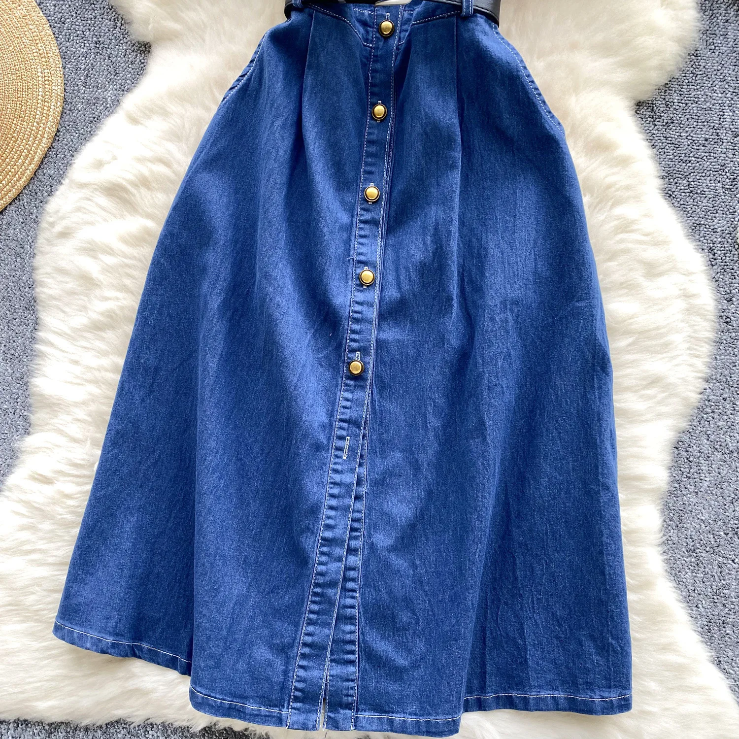 Un nuovo abito in denim alla moda estiva. Abito in denim a vita stretta con cintura monopetto in metallo a maniche corte con collo alto retrò per le donne